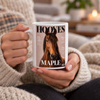 Two hands in a cream sweater holding a white 11 oz mug with a magazine-cover pet portrait of a brown horse
