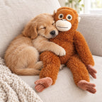 Puppy asleep hugging the Punch Monkey orangutan plush on a sofa